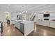 Open kitchen with island, stainless appliances, and seamless flow to the living area at 6949 Rex Rd, Holly Springs, NC 27540