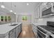 Open-concept kitchen with stainless appliances, white countertops, and hardwood floors at 6949 Rex Rd, Holly Springs, NC 27540