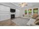 Cozy living room with built-in bookshelves, a fireplace, and large windows, creating a comfortable atmosphere at 6949 Rex Rd, Holly Springs, NC 27540