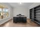 Office with hardwood floors, built-in shelves, and a large window providing natural light at 6949 Rex Rd, Holly Springs, NC 27540