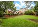Expansive backyard with a patio, lush lawn, and mature trees at 729 Mial St, Raleigh, NC 27608