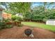 Beautiful backyard featuring a fire pit, lush greenery, mature trees, and a storage shed at 729 Mial St, Raleigh, NC 27608