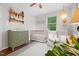 Cozy Bedroom featuring a crib, changing table, and soft natural lighting at 729 Mial St, Raleigh, NC 27608