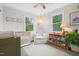 Cozy bedroom featuring two windows, a crib, and a chair with a bookshelf and decorations at 729 Mial St, Raleigh, NC 27608