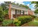 Beautifully landscaped home with brick accents, a cozy front porch, and lush greenery at 729 Mial St, Raleigh, NC 27608