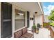 Inviting front porch features a cozy bench, potted plants, and black shutters on the front windows at 729 Mial St, Raleigh, NC 27608