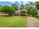 Well-manicured front yard featuring lush green grass, mature trees, and a charming stone walkway at 729 Mial St, Raleigh, NC 27608