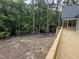 Newly constructed deck overlooks a wooded backyard and prepped yard with black border and green pipe at 79 Oldham Estate Dr, Chapel Hill, NC 27517