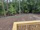 View of the wooded backyard and the prepped yard with black border and green pipe at 79 Oldham Estate Dr, Chapel Hill, NC 27517
