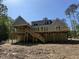 Exterior view of a new home featuring large wooden deck with stairs leading to the backyard at 79 Oldham Estate Dr, Chapel Hill, NC 27517