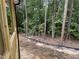 View of the undeveloped backyard with trees surrounding the property and new construction features at 79 Oldham Estate Dr, Chapel Hill, NC 27517
