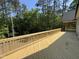 Newly constructed wood deck featuring wood railings with a view of the surrounding woods at 79 Oldham Estate Dr, Chapel Hill, NC 27517