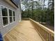 Side view of the new wooden deck surrounded by lush greenery and freshly painted siding at 79 Oldham Estate Dr, Chapel Hill, NC 27517