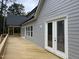 Exterior view of home featuring the deck, freshly painted gray siding and windows with wooded backdrop at 79 Oldham Estate Dr, Chapel Hill, NC 27517