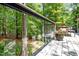 The back deck features glass paneled railings with wooded views, adding style and unobstructed enjoyment of nature at 800 Shady Lawn Rd, Chapel Hill, NC 27514