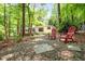 Home's backyard boasts mature trees and a private sitting area with wooded views, creating a relaxing outdoor space at 800 Shady Lawn Rd, Chapel Hill, NC 27514