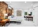 Spacious bedroom featuring exposed brick accent wall and modern minimalist decor at 800 Shady Lawn Rd, Chapel Hill, NC 27514