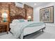 Well-lit bedroom features a bed with wooden frame and exposed brick accent wall at 800 Shady Lawn Rd, Chapel Hill, NC 27514