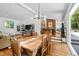 Open-concept dining area with a long wooden table, modern chandelier, and view to the living room at 800 Shady Lawn Rd, Chapel Hill, NC 27514