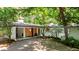 Ranch home with white painted brick, wood details, and mature landscaping in a wooded setting at 800 Shady Lawn Rd, Chapel Hill, NC 27514