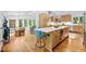 Bright kitchen with a large island, hardwood floors, bar stools, and stainless steel appliances at 800 Shady Lawn Rd, Chapel Hill, NC 27514