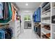 Spacious walk-in closet with built-in shelving and drawers for ample storage, with laundry room in the background at 800 Shady Lawn Rd, Chapel Hill, NC 27514