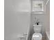 Simple bathroom featuring a white toilet, tiled floors, and a small window at 803 W Club Blvd, Durham, NC 27701