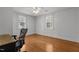 Bedroom featuring hardwood floors, white walls, two windows with blinds, and a ceiling fan with light at 803 W Club Blvd, Durham, NC 27701