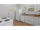Galley-style kitchen with white appliances, ample counter space, and linoleum flooring at 803 W Club Blvd, Durham, NC 27701