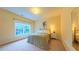This bright bedroom includes a bed, nightstand, window overlooking trees, and mirror at 99 Grassy Creek Way, Chapel Hill, NC 27517