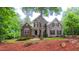 Charming two-story home featuring a stone facade and beautiful landscaping with mature trees at 99 Grassy Creek Way, Chapel Hill, NC 27517