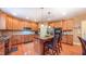 Well-lit kitchen boasts custom wood cabinetry, stainless appliances, and granite countertops with a central island at 99 Grassy Creek Way, Chapel Hill, NC 27517