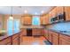 This kitchen offers wood cabinets, granite counters, stainless appliances, and a window with a backyard view at 99 Grassy Creek Way, Chapel Hill, NC 27517