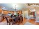 Open-concept kitchen and dining area with hardwood floors, stainless appliances, and bar seating at 99 Grassy Creek Way, Chapel Hill, NC 27517