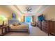 Elegant main bedroom features a tray ceiling with a ceiling fan, sitting area, and large window at 99 Grassy Creek Way, Chapel Hill, NC 27517