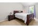Cozy bedroom with a dark wooden bed frame and matching nightstand, lit by natural light at 101 Kristina Dr, Selma, NC 27576