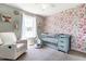 Charming Bedroom with floral wallpaper, a blue crib, and a comfortable white glider chair at 101 Kristina Dr, Selma, NC 27576