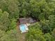 Aerial view showcases an in-ground pool and sprawling property surrounded by mature trees at 102 Mel Oak Dr, Chapel Hill, NC 27516