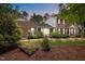 Beautiful brick home with mature landscaping, a cozy sunroom, and lush twilight greenery at 102 Mel Oak Dr, Chapel Hill, NC 27516
