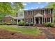 Charming brick home with black shutters, an American flag, and beautiful landscaping at 102 Mel Oak Dr, Chapel Hill, NC 27516