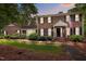 Charming brick home with black shutters, an American flag, and beautiful landscaping at twilight at 102 Mel Oak Dr, Chapel Hill, NC 27516