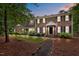 Charming brick home with black shutters, an American flag, and beautiful landscaping at twilight at 102 Mel Oak Dr, Chapel Hill, NC 27516