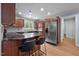 Well-lit kitchen featuring dark wood cabinets, stainless steel refrigerator, and a granite breakfast bar at 102 Mel Oak Dr, Chapel Hill, NC 27516