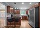 Bright kitchen boasts dark wood cabinetry, stainless steel appliances, and a stylish breakfast bar with seating at 102 Mel Oak Dr, Chapel Hill, NC 27516