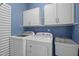 Laundry room with modern washer, dryer, utility sink, and blue walls at 102 Mel Oak Dr, Chapel Hill, NC 27516