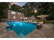 Beautiful in-ground pool with travertine tile surround and a stone waterfall feature at 102 Mel Oak Dr, Chapel Hill, NC 27516