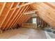 A large unfinished attic area with rafters, a single window, and plywood flooring at 103 Castill Pl, Garner, NC 27529