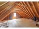 The expansive, unfinished attic features exposed rafters, plywood flooring, and a small window at 103 Castill Pl, Garner, NC 27529