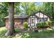 Exterior view of a well-maintained home with brick accents and a lush green lawn and mature trees at 103 Castill Pl, Garner, NC 27529
