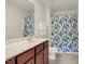 Bathroom features wood cabinets, a marble-look countertop, tile floors, and a shower with modern curtain at 106 Elmsford St, Durham, NC 27703